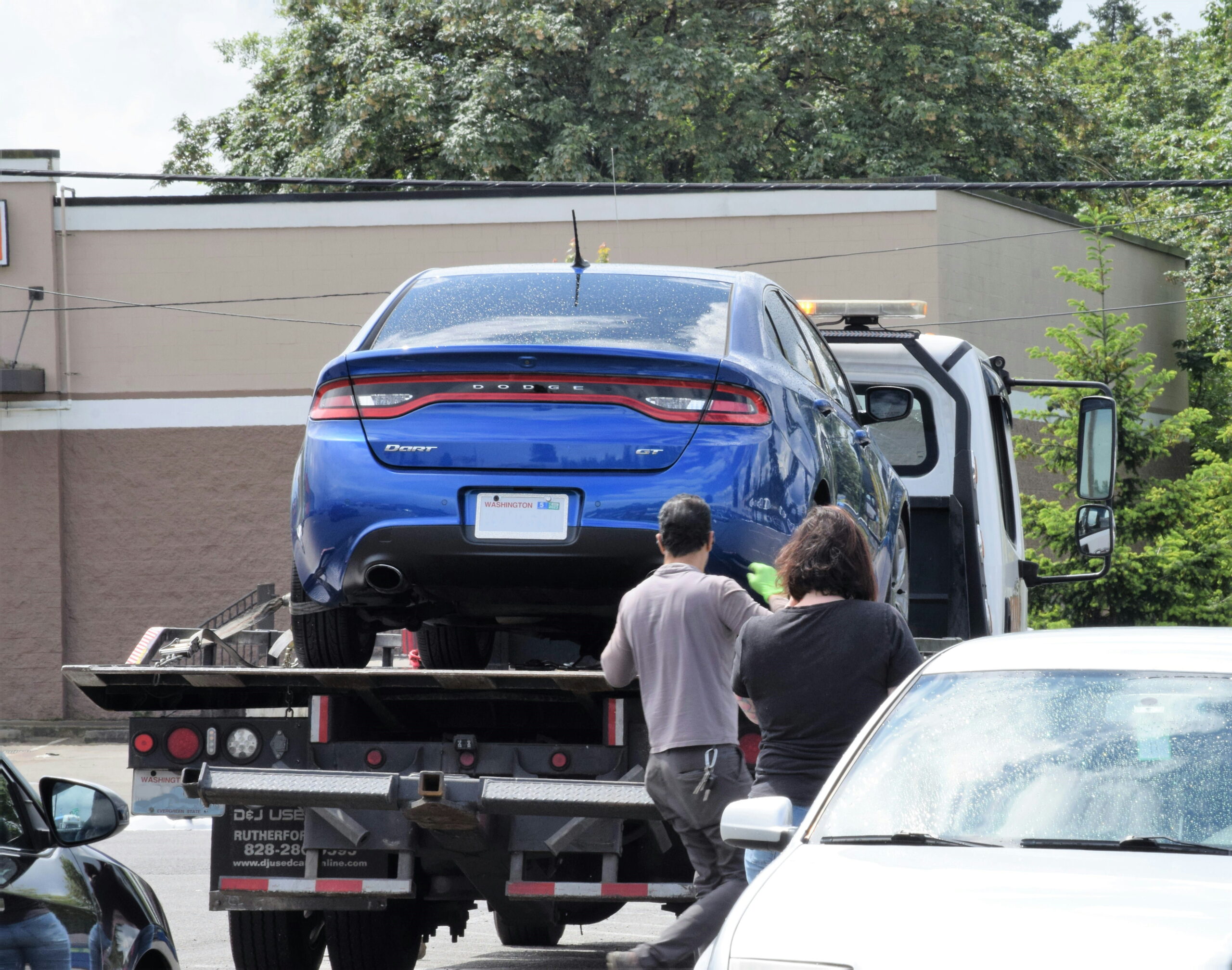 Basra Auto Towing crew loading a customer's car onto a tow truck